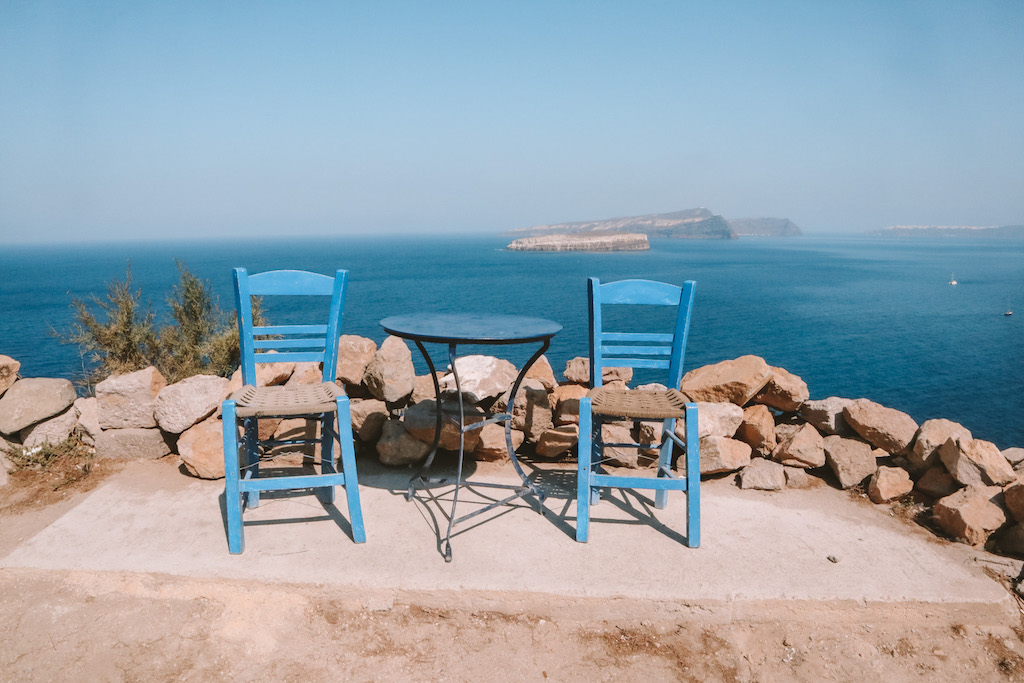 Sitzecke mit blauen Stühlen und perfekter Aussicht auf Santorini