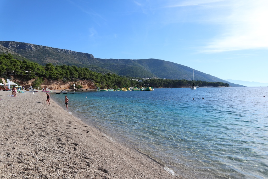 Zlatni Rat in Bol, weitläufiger Strand mit Bergen im Hintergrund